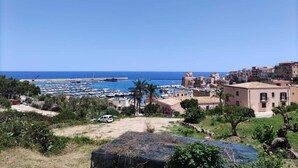 Une ville côtière dotée d’un port de plaisance, de bâtiments et d’un ciel bleu azur.