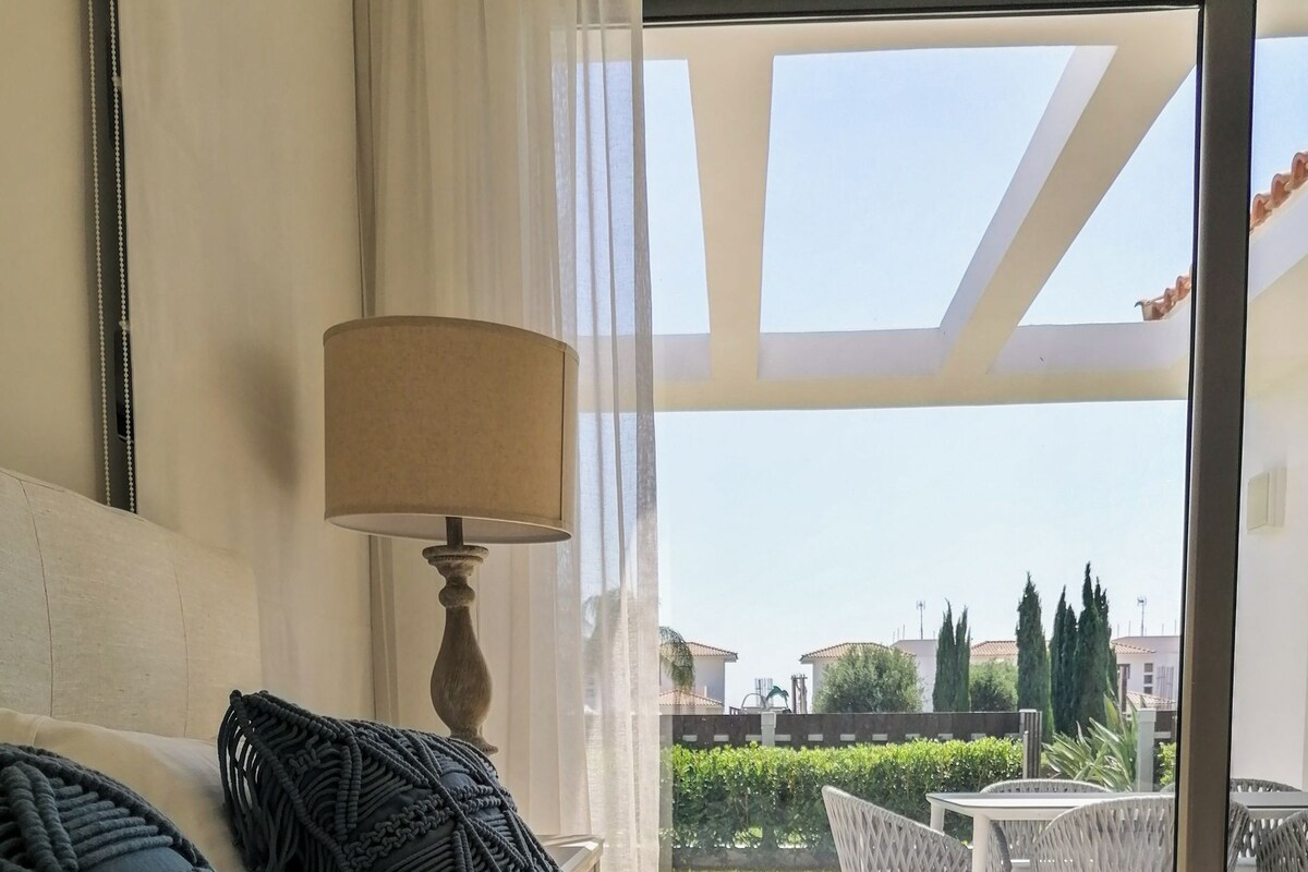 Ein Schlafzimmer mit Bett, Lampe und Blick ins Freie.