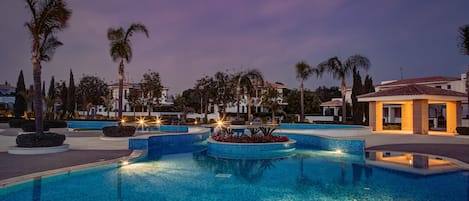 Una piscina al aire libre de temporada, sombrillas