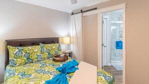 A hotel room with a bed, a nightstand, a lamp, and a view of the outside. - Seaglass Serenity M112 NEW IN '24 (Galveston)
