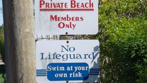 A sign indicating a private beach for members only with no lifeguard. - Cleves Point Estates Home, Private sandy beach (Greenport)