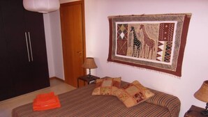 Une chambre à coucher comprenant un lit, une armoire, une table de chevet et un élément décoratif mural.
