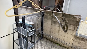 A metal staircase with a metal railing, a concrete wall, and a metal fence.