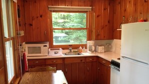 A kitchen with wooden cabinets, a microwave, a coffee maker, and a refrigerator.