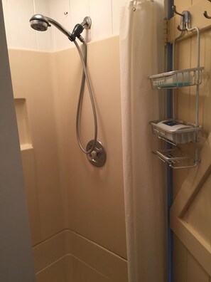 Een douche, handdoeken, zeep, toiletpapier