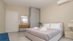 Ein Schlafzimmer mit Bett, Nachttisch, Kleiderschrank, Spiegel und Tür.