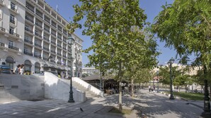 Un hôtel à plusieurs étages, doté d’un espace extérieur aménagé et d’un escalier menant à l’entrée.