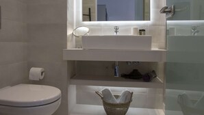 Une salle de bain moderne équipée de toilettes, d’un lavabo et d’une zone douche.