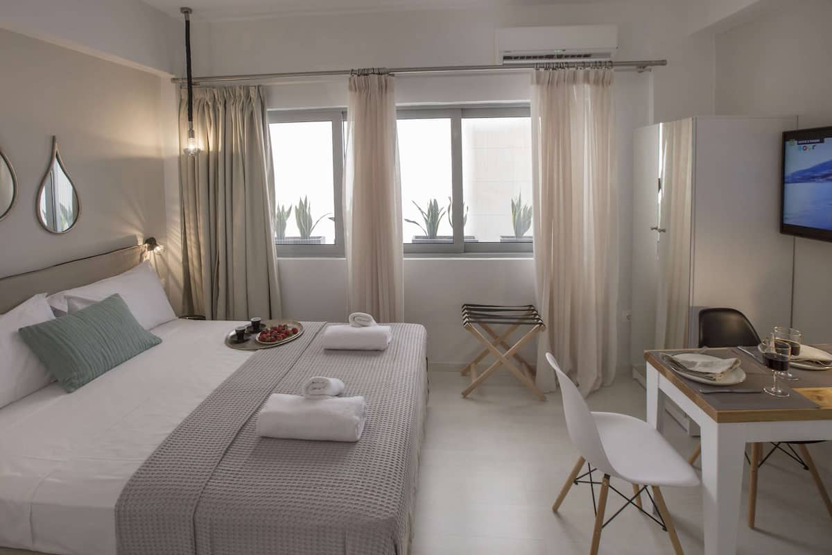 Ein Hotelzimmer mit Bett, Schreibtisch und Fernseher.