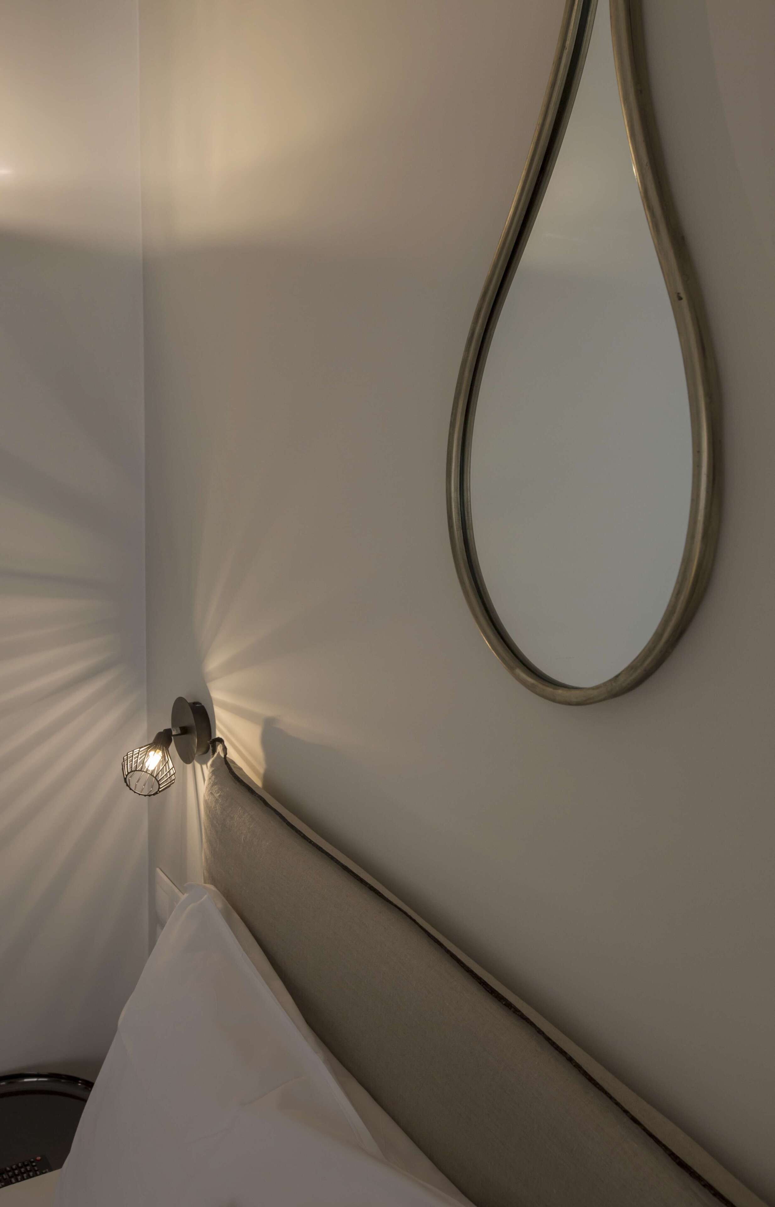 A bathroom with a mirror, a towel, and a light fixture.