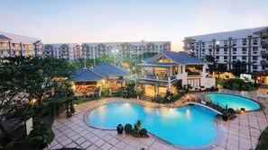 Ein Resort mit großem Schwimmbad, mehreren Gebäuden und gepflegten Gärten.