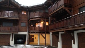 Un immeuble en bois à plusieurs étages, doté de balcons et d’un garage.