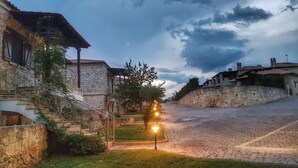 A stone pathway leading to a stone building with a staircase and a lamp post. - Luxurious Stone House in Elani (ΑΜΑ : 00000239911) (Siviri, Chalkidiki)