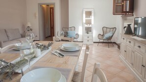 A dining area with a wooden table set for two, two chairs, and a buffet cabinet. - CASALE LA FATA, SMEMORINA splendid apartment facing the pool, sleeps 5 (camaiore)