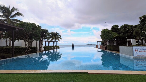 An infinity pool with a clear view of the sea and palm trees. - Luxury 3BR House With Direct Access To Private Beach (Klaeng)
