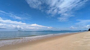 A wide beach with clear blue water and a sandy shore. - Luxury 3BR House With Direct Access To Private Beach (Klaeng)