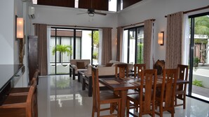 A spacious living area with a dining table, chairs, sofas, and a ceiling fan. - Luxury 3BR House With Direct Access To Private Beach (Klaeng)