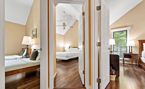 Una camera da letto con due letti, una ventola a soffitto e una finestra con persiane.