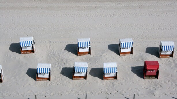Strandstoelen rijend op een zandstrand.