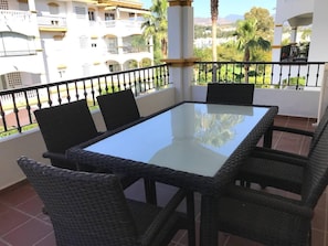 Relax on the balcony with a glass-top table and wicker chairs, taking in views of the surrounding residential area.