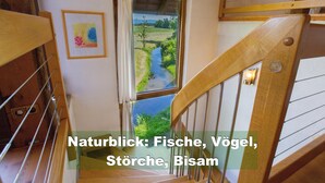 Eine Treppe mit Blick auf einen Fluss und grüne Landschaft.