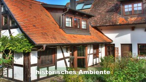 Ein traditionelles Fachwerkhäuschen mit geneigtem Dach und Schornstein.