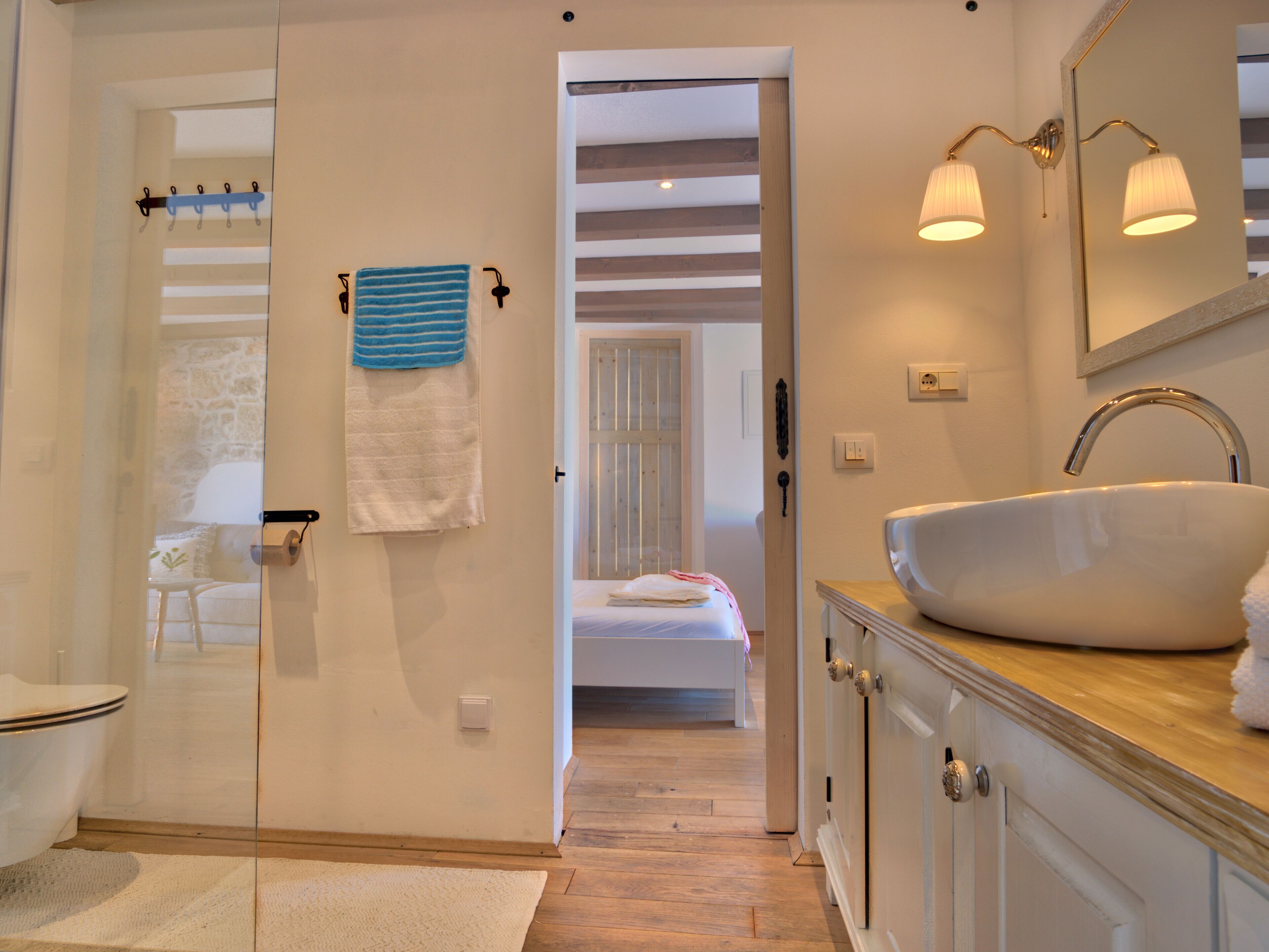 A bathroom with a white sink, a mirror, and a towel rack.