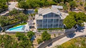 Un edificio grande de varios pisos con piscina y un muro de contención de piedra.
