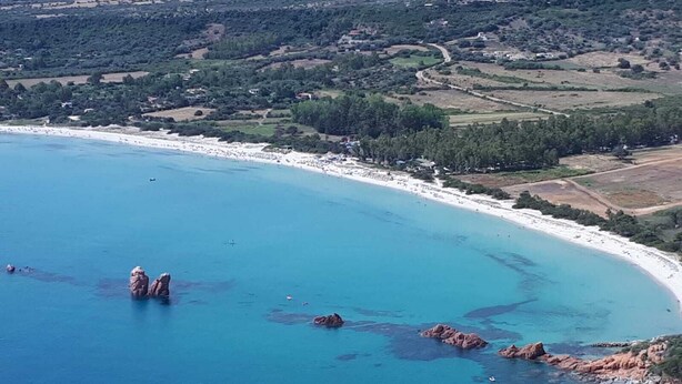 An aerial view of a coastal area with a beach, rocky outcrops, and surrounding greenery. - Giorgio Holiday Home. Comfort and Relax for the Family, Just Steps from the Sea (Bari Sardo)