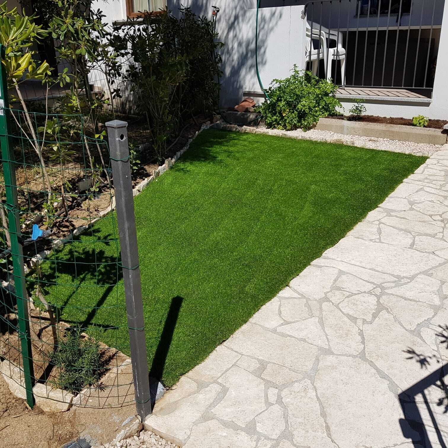A well-maintained lawn with a stone pathway leading to a white building.