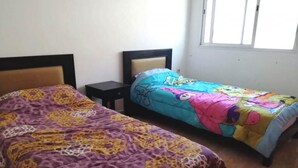 Un dormitorio con dos camas, cada una con un edredón de estampado diferente.