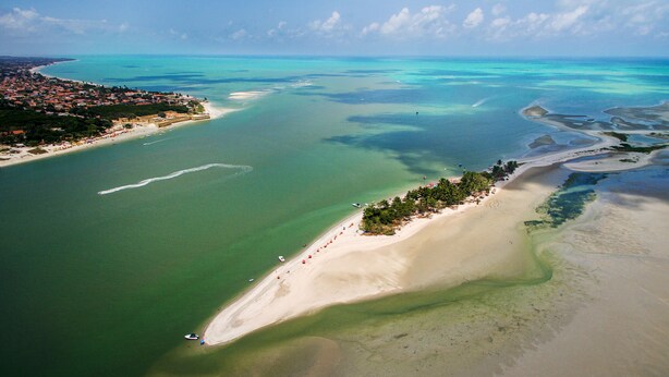 An aerial view of a coastal area with a beach, clear waters, and a small island with vegetation. - Manga Verde Beach 03: Pool and Beach view H (Pilar)