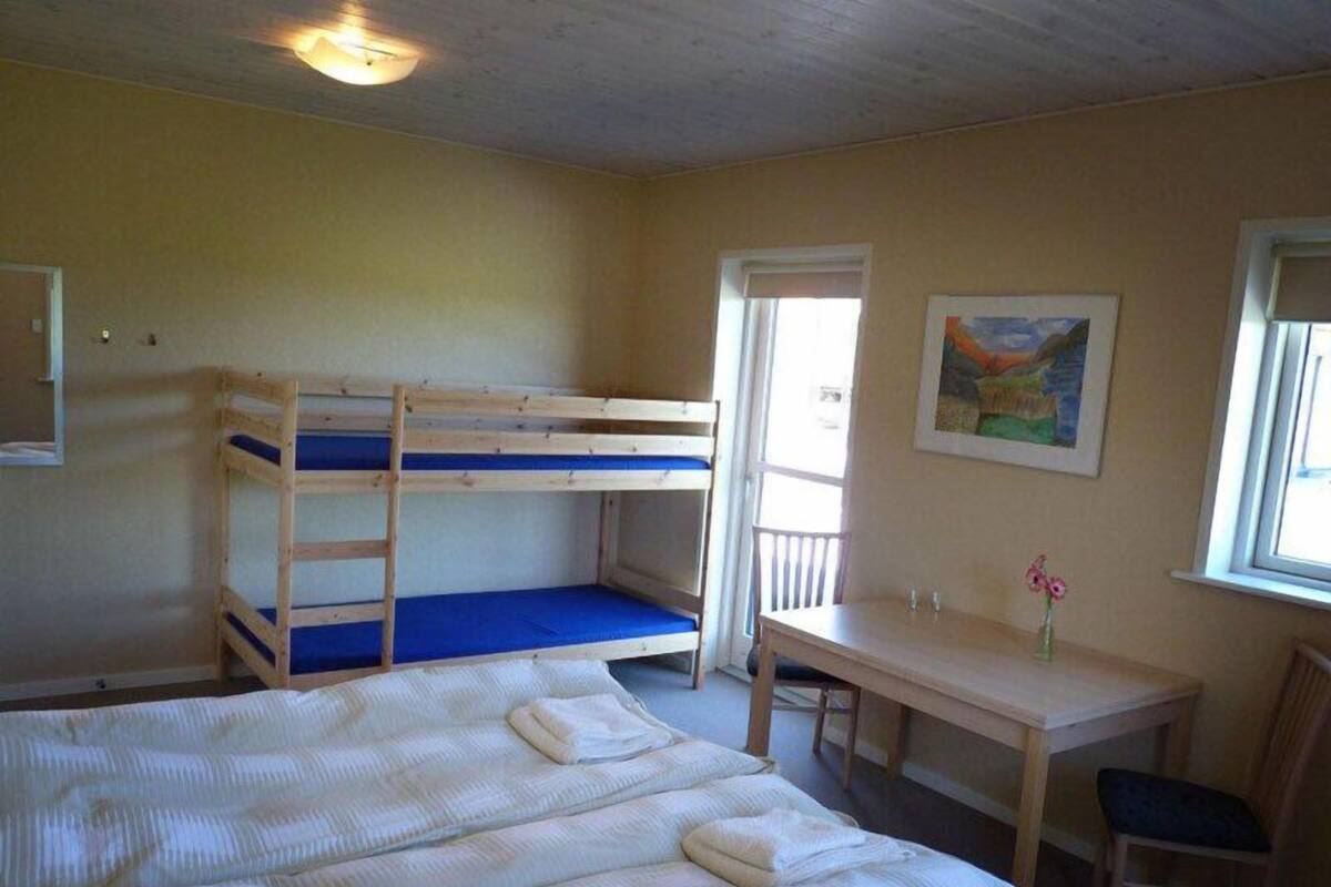 Ein Zimmer mit Stockbetten, einem Schreibtisch und einem Stuhl.