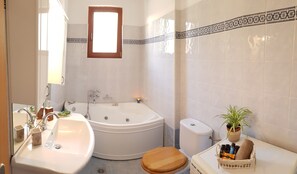 Bathtub, hair dryer, towels, shampoo