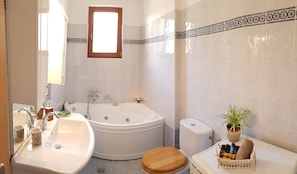 Bathtub, hair dryer, towels, shampoo