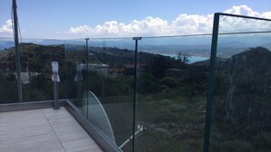 Un balcon doté d’une balustrade en verre, offrant une vue panoramique sur un paysage magnifique.