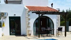 Une maison moderne dotée d’une piscine, d’un espace salon extérieur et d’une pergola.