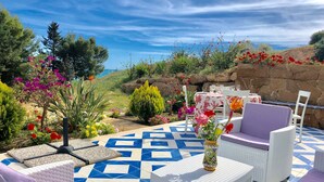 A patio with white wicker furniture, a patterned tile floor, and a view of the sea. - NARCISO by KlabHouse-2pax w/AC&terrace walk2beach (Sciacca)