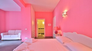 A pink-themed hotel room with a bed, a white sofa, and a nightstand with a lamp. - NARCISO by KlabHouse-2pax w/AC&terrace walk2beach (Sciacca)