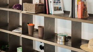 A bookshelf with various books, a television, and decorative items. - We saw athens from 1a (Αθήνα)
