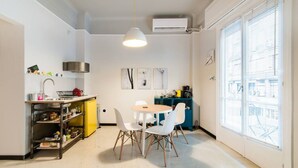 A compact kitchen with a dining area, white walls, and a large window. - We saw athens from 1a (Αθήνα)