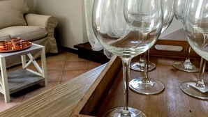 Una habitación con una mesa de madera que sostiene varios vasos de vino y una bandeja con copas color cobre.