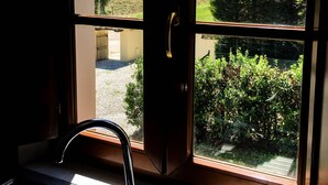 Una cocina con ventana que da a un jardín y una puerta metálica.