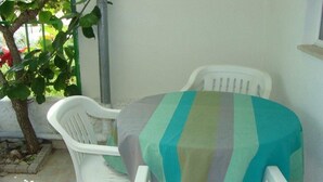 A small outdoor seating area with two white plastic chairs and a table covered with a striped tablecloth. - Apartment in Sukošan with Terrace, Air condition, WIFI (131-3) (Sukošan)