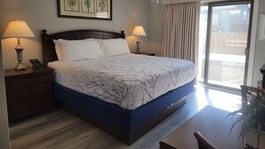 A hotel room with a large bed, two bedside lamps, a ceiling fan, a window with curtains, and a framed picture on the wall. - Last MINUTE CANCELLATION- 8/1-8/8 NOW $2200.00 2BR/2BA @ CLUB OCEAN VILLAS II (Ocean City)