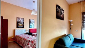 Une pièce avec un lit, un canapé et un tableau au mur.
