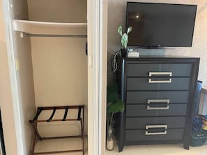 A room with a wardrobe, a television on top, and a small plant. - AMAZING Condado del Mar Studio - Steps to Beach/Pool (Santurce)