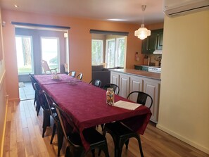 A dining area with a red tablecloth, chairs, and a bottle of nuts. - Stopover 471: Tranquility on Lake Champlain (Venise-en-Québec)
