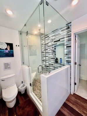 Een bad/douchecombinatie, een bubbelbad, een haardroger, handdoeken