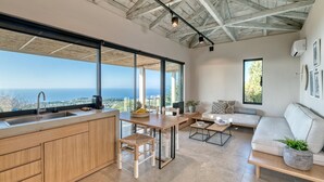 A modern kitchen with a large island, a dining area with a view, and a living area with a sofa and a coffee table. - Residence with Private Pool - with Panoramic View, Art Blue Villas (Lefkada)